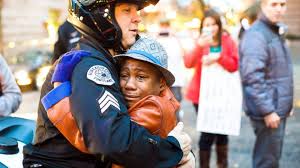 White officer -- one of the good guys -- hugs a black boy who is crying from fear that police officers might kill him because he's black. Officer Bret Barnum and Devonte Hart.