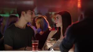 Girl talks to guy at bar